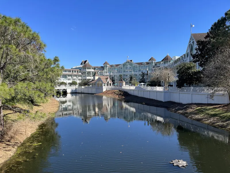 Disney's Beach Club Resort, pastel Victorian-style buildings reflected in a canal under a clear blue sky