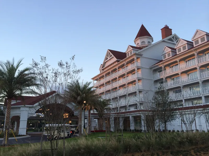 The Villas at Disney's Grand Floridian, a white Victorian-style building with gabled roofs and long balconies, beside its porte-cochere